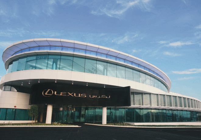 Lexus Kuwait showroom — curved glass facade at dusk